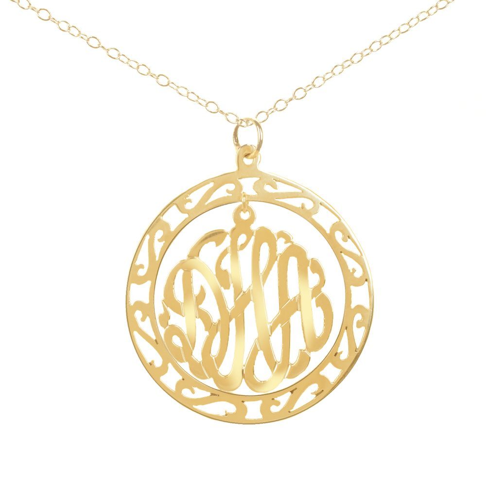 14K gold round monogram necklace hanging inside a hollow patterned circle pendant